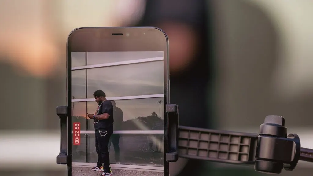 Pessoa gravando conteúdo com smartphone apoiado em tripé